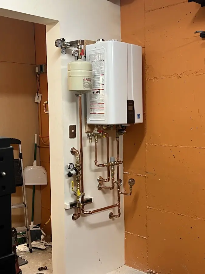 Plumbing technician inspecting water heater connections in Minnetrista